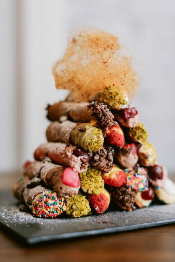 Eat Cannoli, colourfully decorated cannoli that is stacked in a pyramid