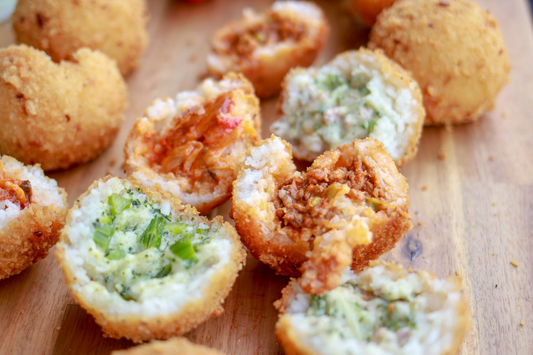 multiple arancini with different fillings in the middle